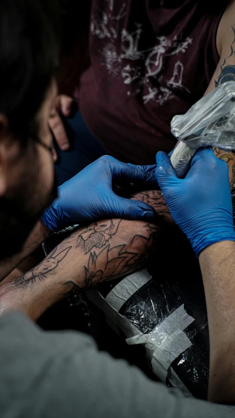 tattoo artist holding his arm to the other person