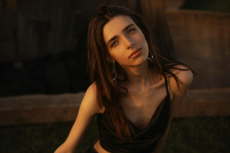 a woman in black and brown dress sitting on the grass