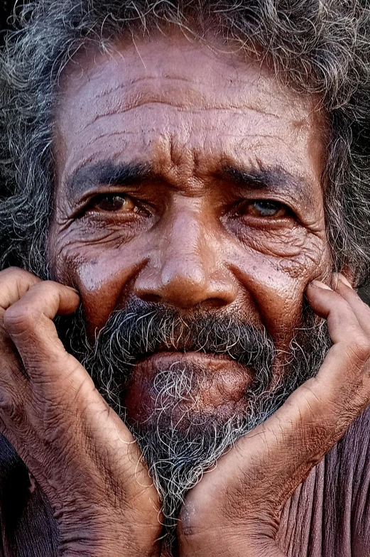 a close up of an old man with long hair