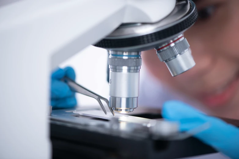 someone using a microscope to examine soing on the ground