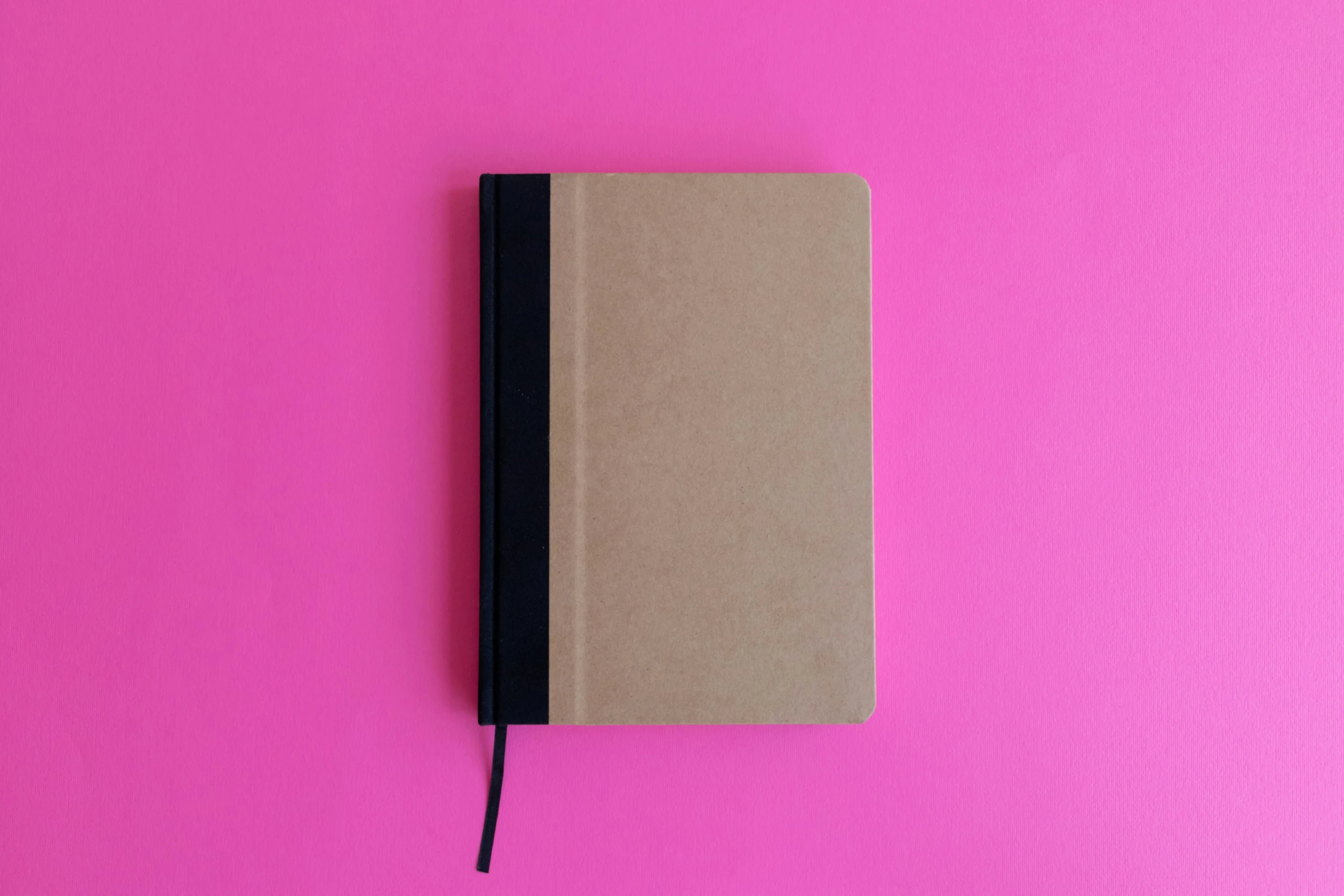 notebook laying on top of a pink background