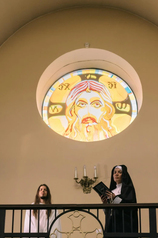 two girls reading in the chapel under a stained glass window