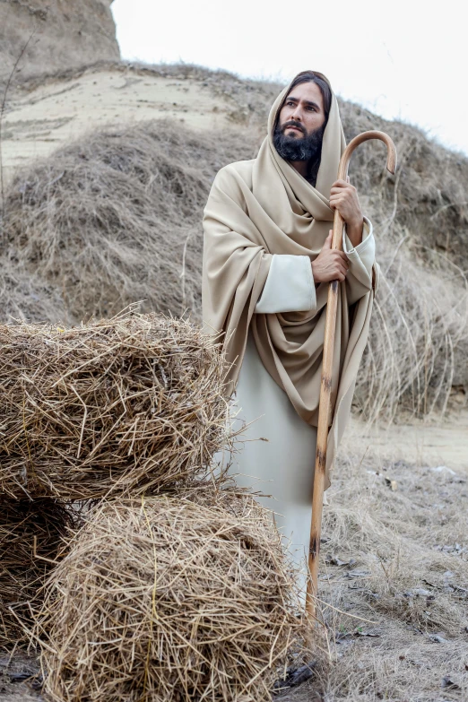 a man with a stick and a pile of straw