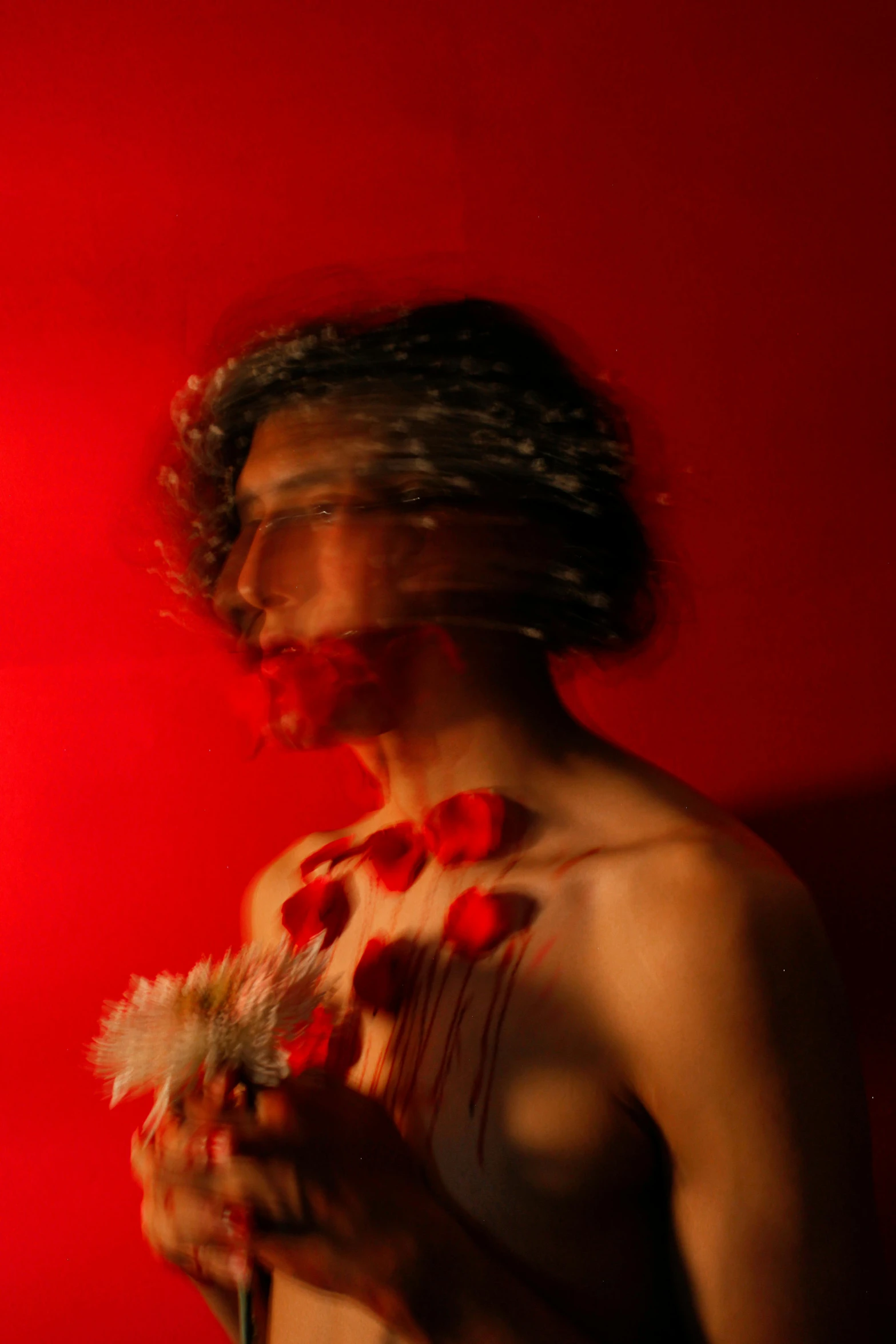 a man looking up while holding a flower