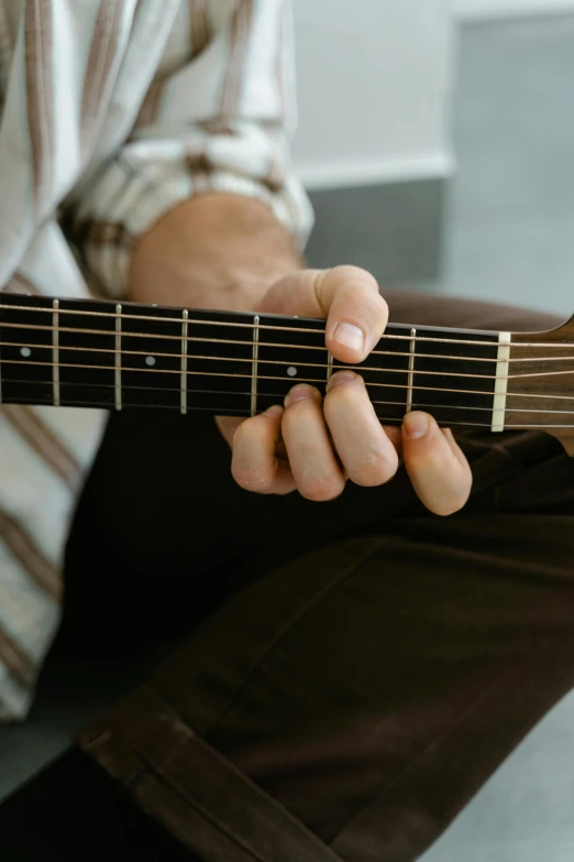 a person is holding a guitar in their hand