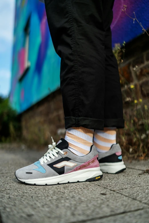 the feet of a person wearing striped socks and sneakers