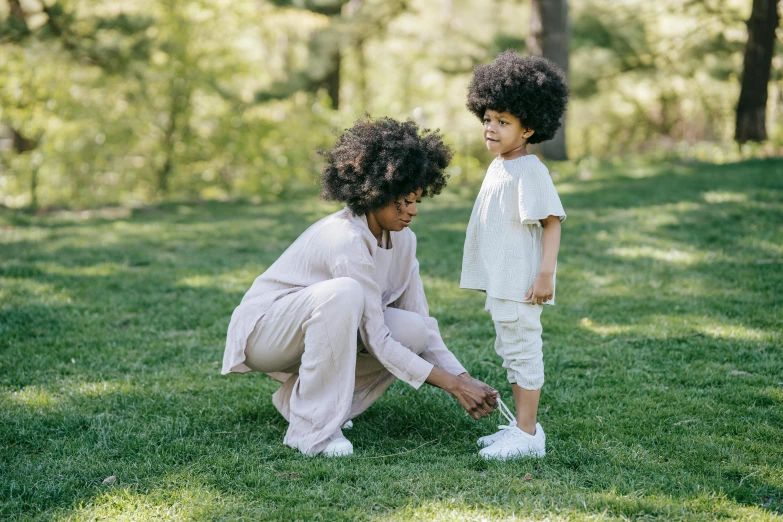 a mother and son standing in a field of grass