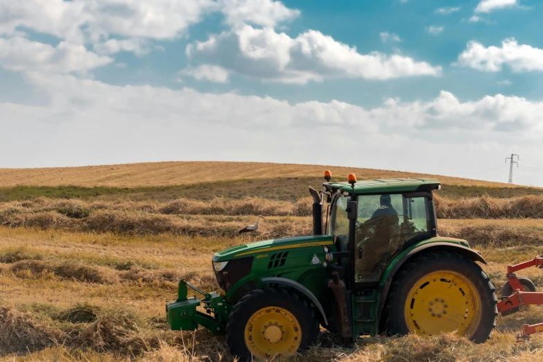 the tractor is driving through the brown grass