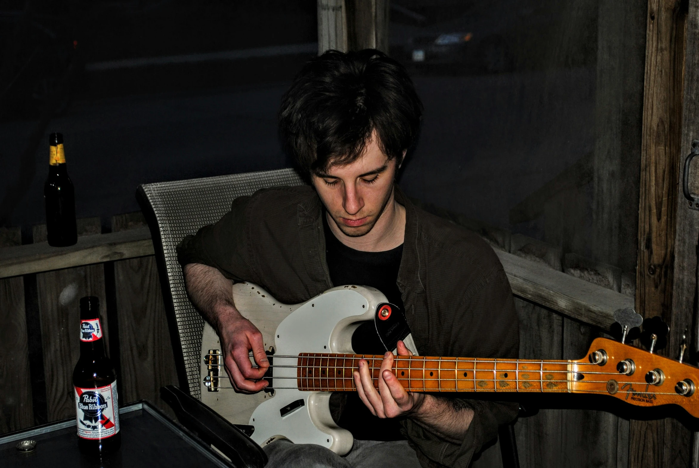 man playing a guitar while sitting at a table