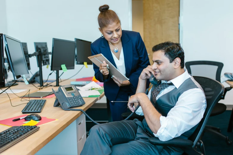 the man is sitting in the chair at the computer desk looking at soing