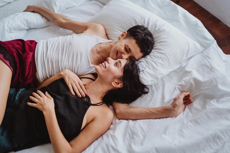 a man and woman cuddled up together in bed