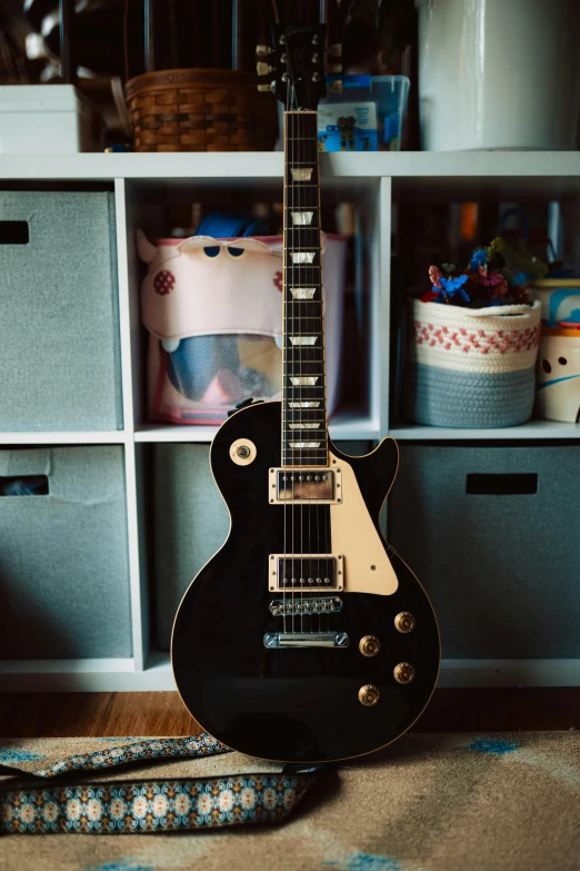 a black guitar and its strap are sitting on a table