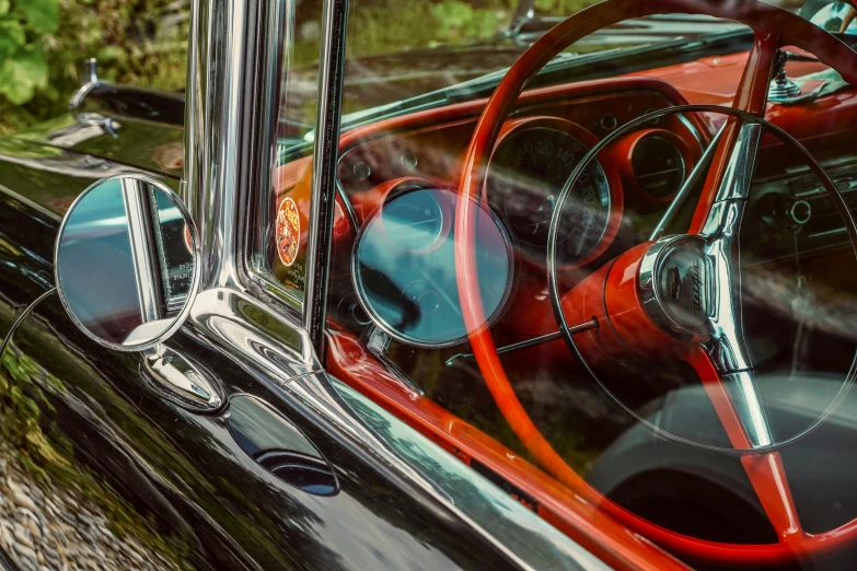 an old classic car's dashboard, with a steering wheel in the reflection