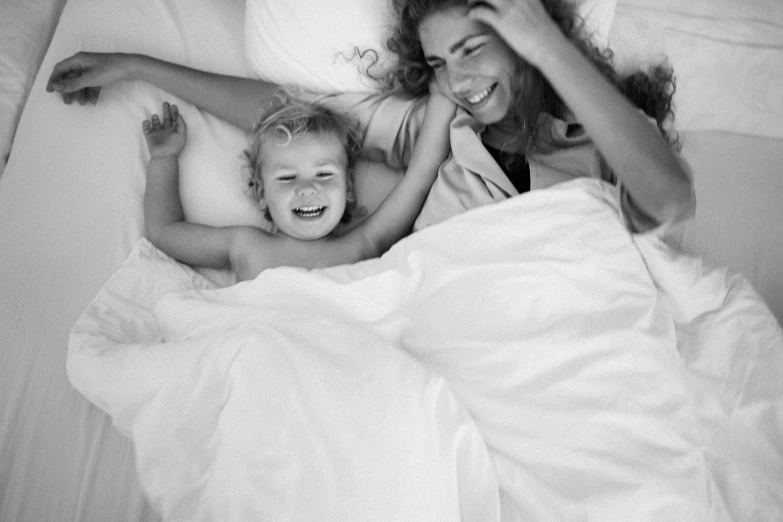 a couple of girls laying in a bed