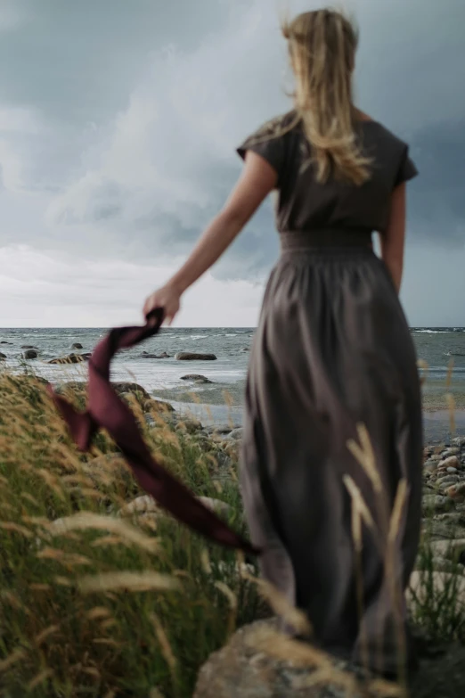 a woman in a dress walking on a beach