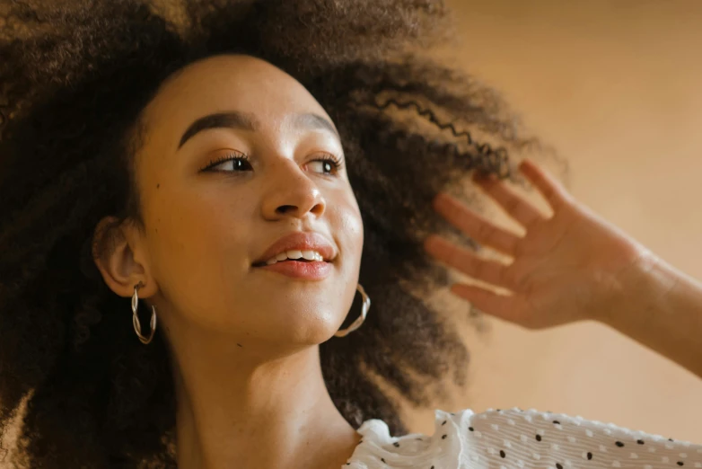 a woman holding her hand up near her face