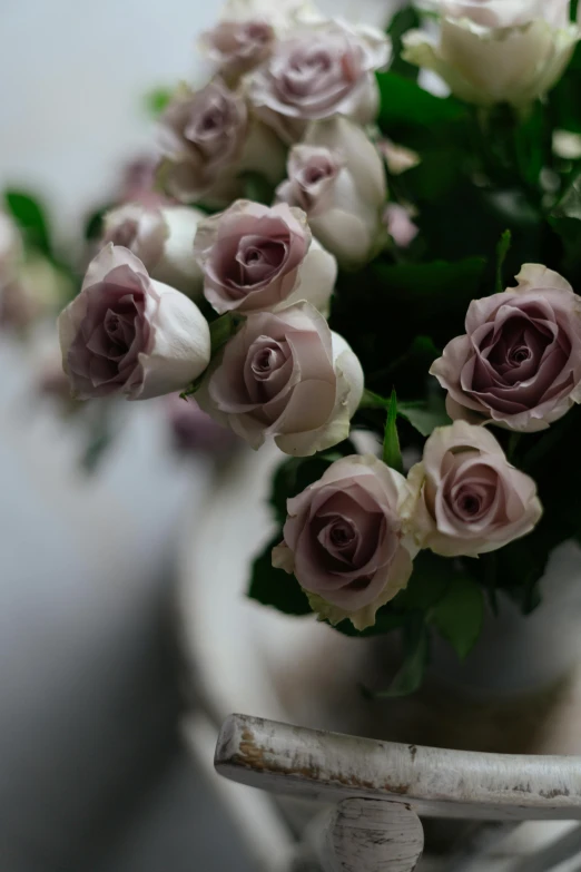 an arrangement of roses in a vase on a table