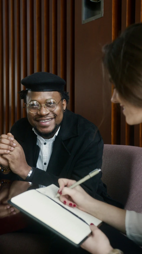 a man sitting on a couch holding a pen