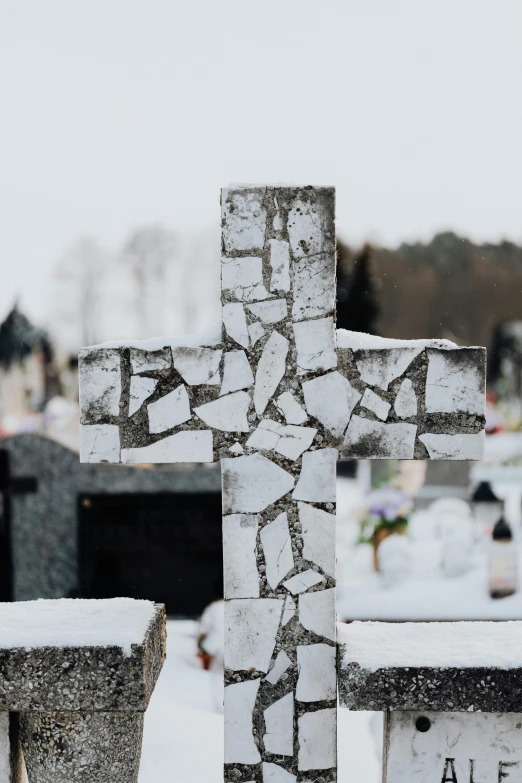 a stone cross sits in the middle of a cemetery