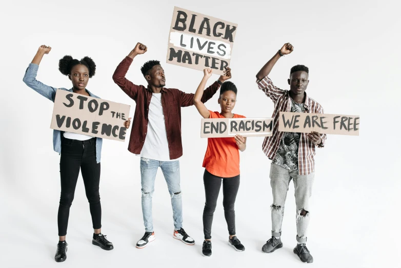 five people standing in front of a white background holding signs