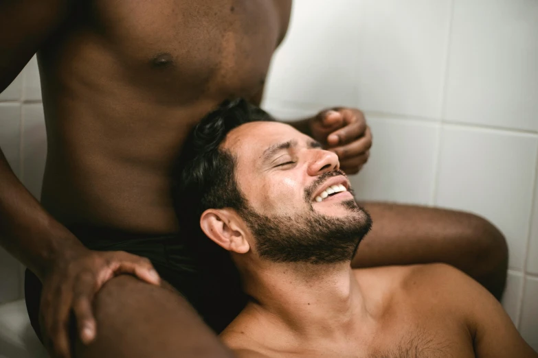 a man standing next to another man in a bathroom