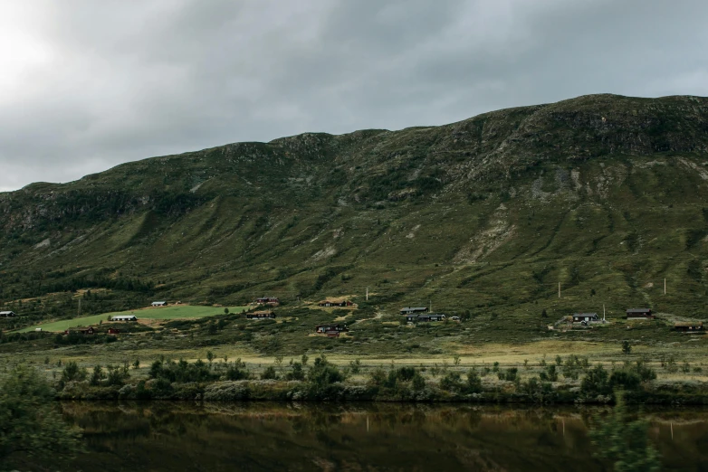 a scenic view of a hill near a lake