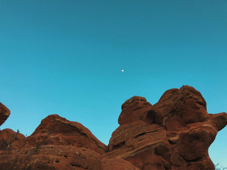 a mountain covered in red rocks under a bright blue sky