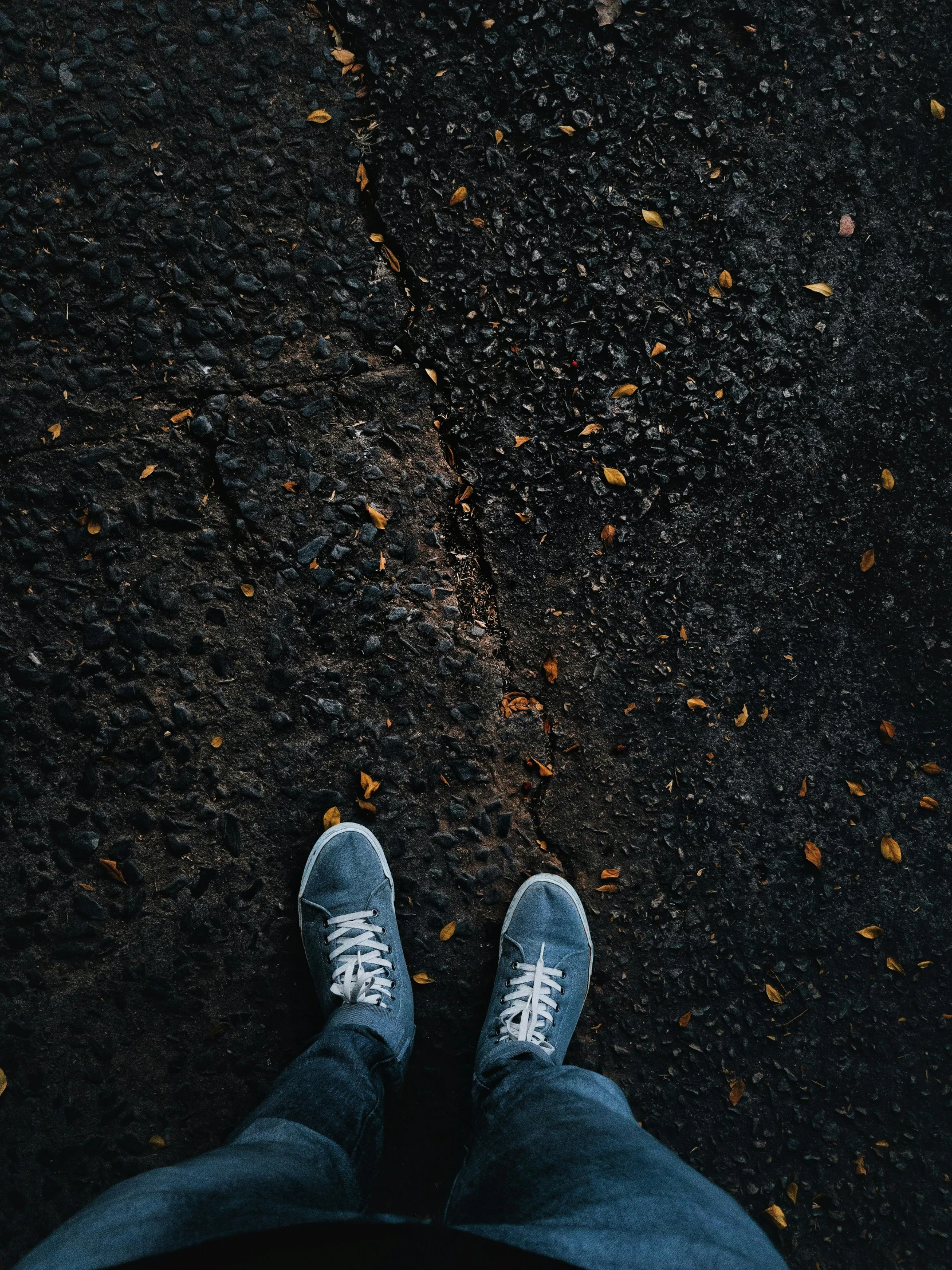 person standing with his feet crossed on top of his black pants