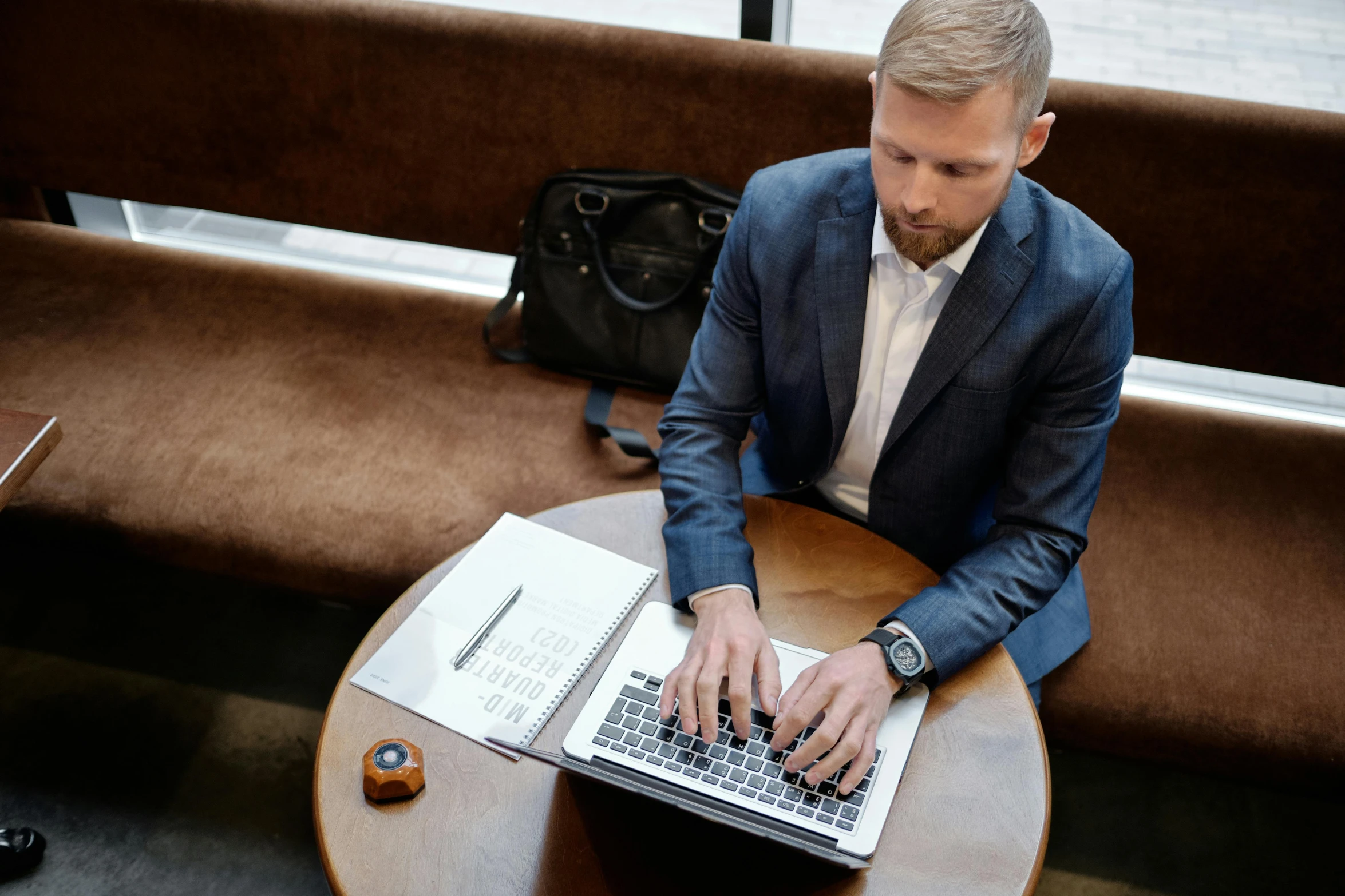 a man sitting on a bench using a laptop