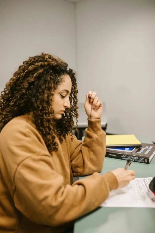 a woman sitting at a desk with her hands folded on a note pad