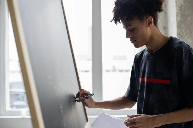 a young person is writing on a board