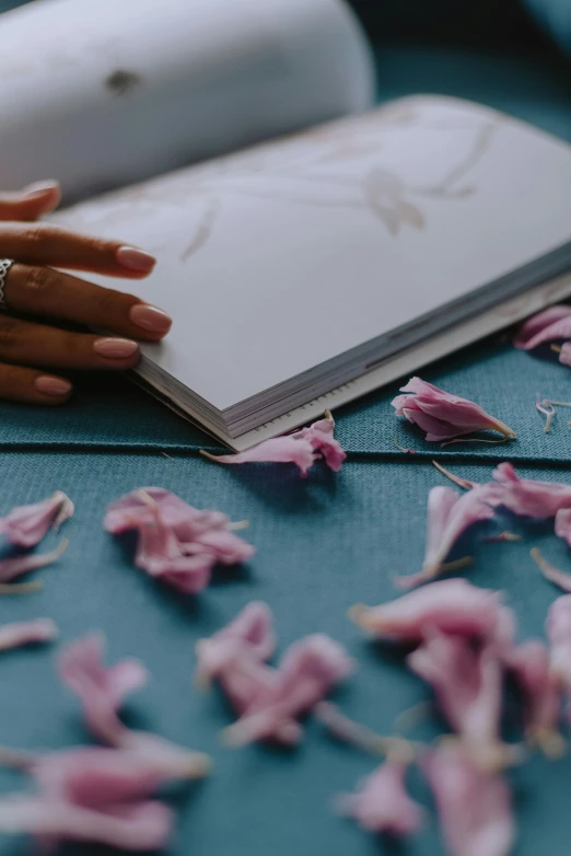 someone's hands holding a ring near a book