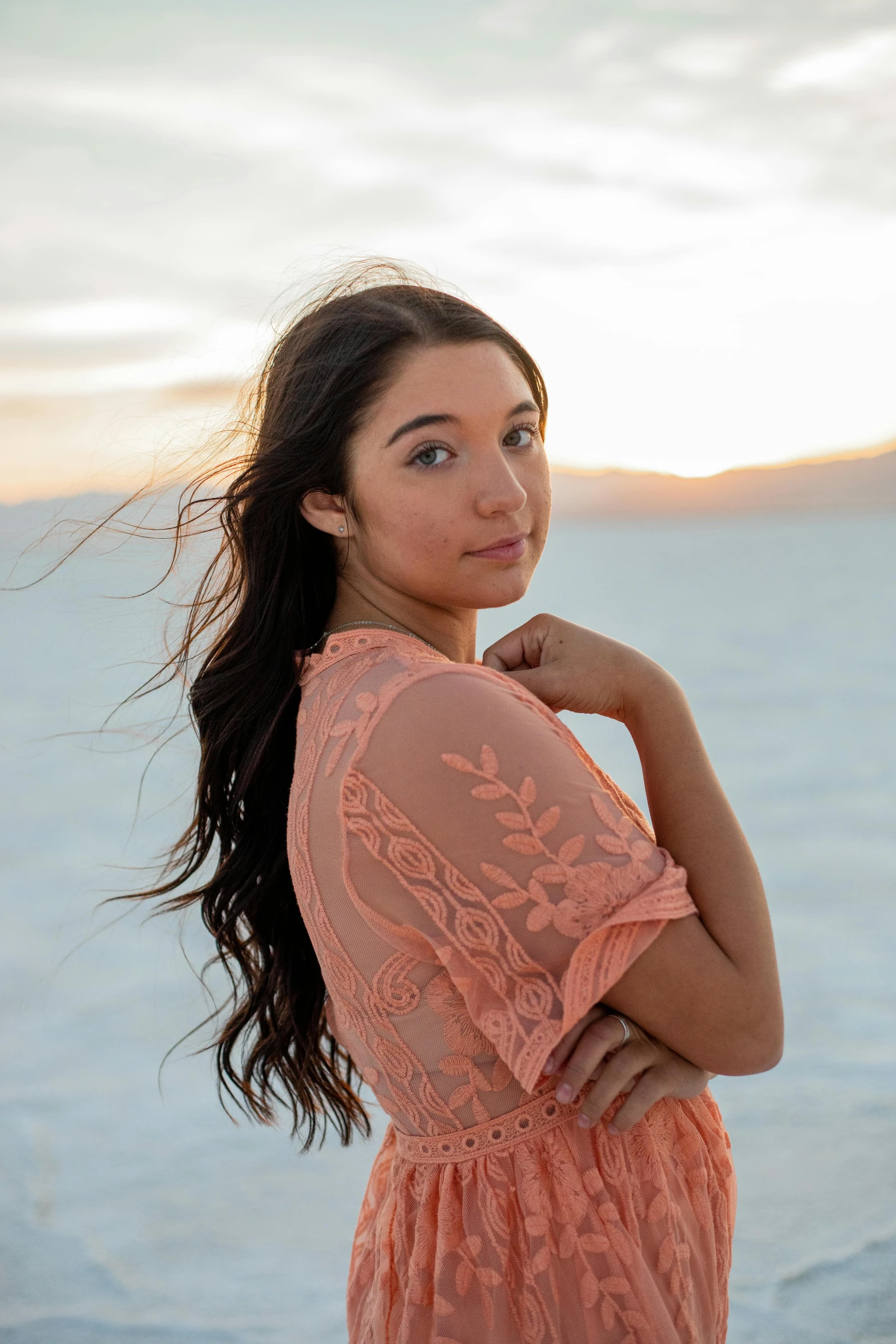 a beautiful young lady standing on the beach posing for a portrait