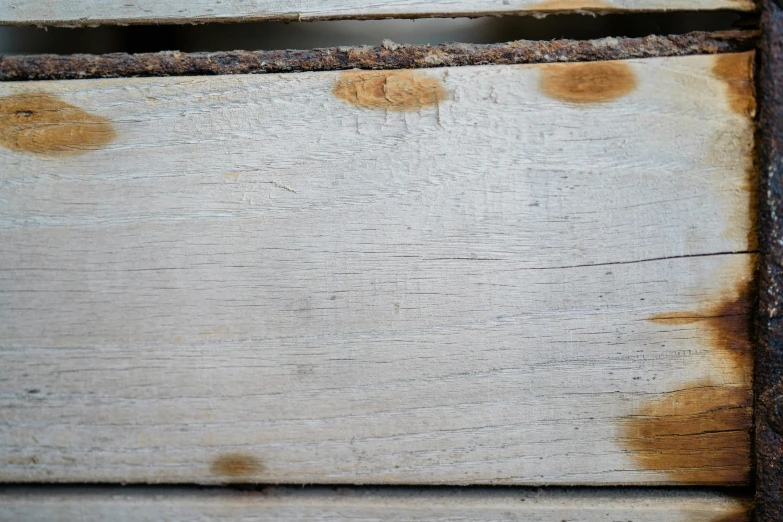 brown stains on white wooden boards, and one small object