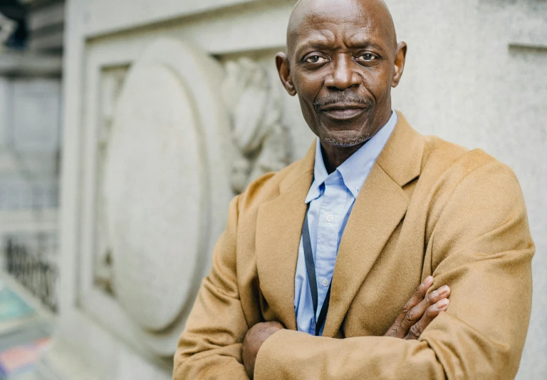 a man in a suit and tie leaning against a wall