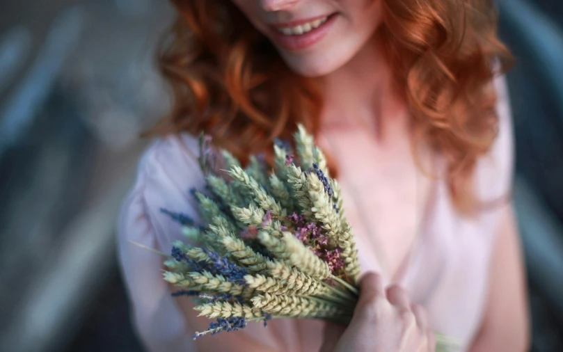 a woman holds out some flowers for the camera