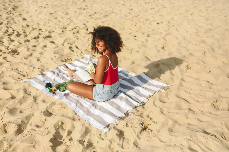 a young woman on a towel on the beach