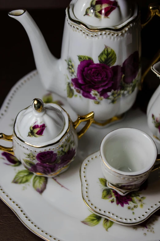 a porcelain tea set on top of a small plate