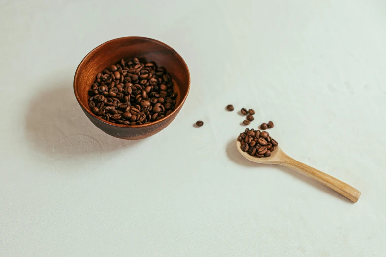 a spoon and some coffee beans sitting on a table