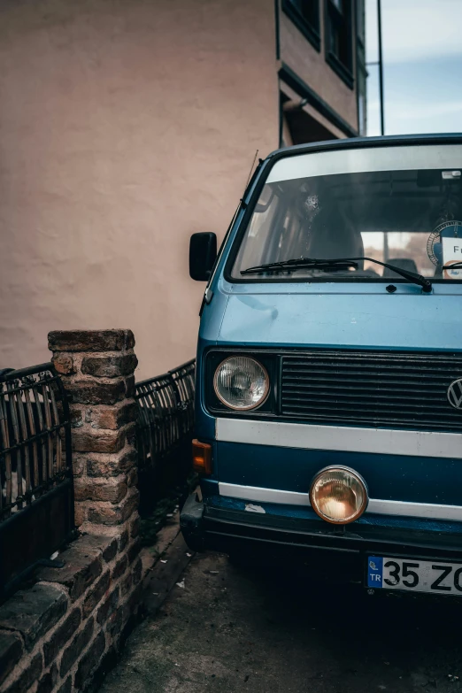 the old volkswagen van is parked by a fence