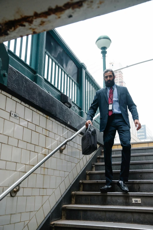 a man in a suit is walking up stairs with luggage