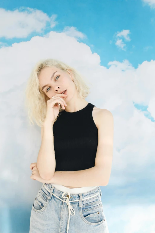 a woman posing for a picture in front of clouds