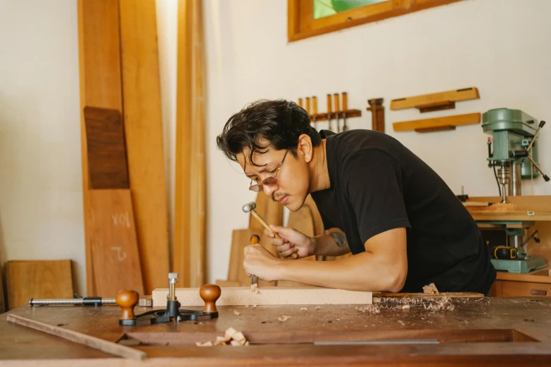 a man working with some woodenworking tools