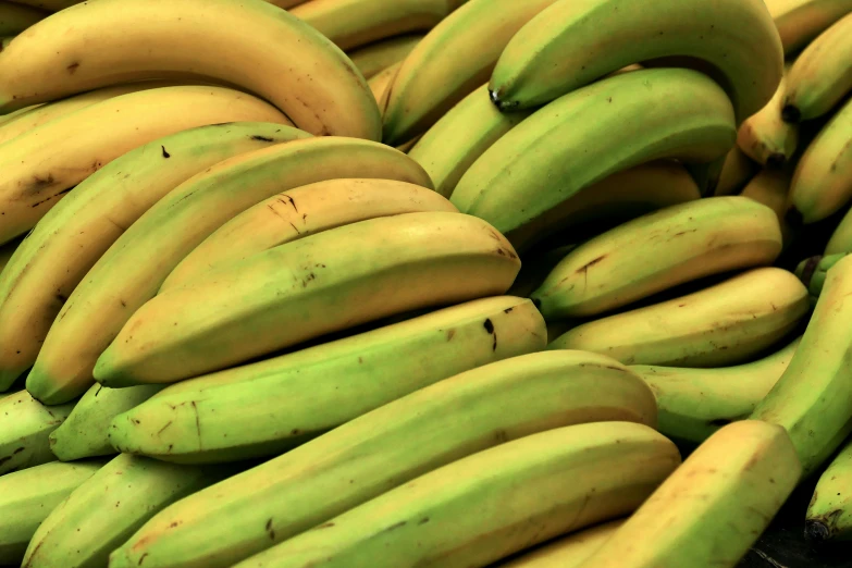 a close up of some green bananas and yellow