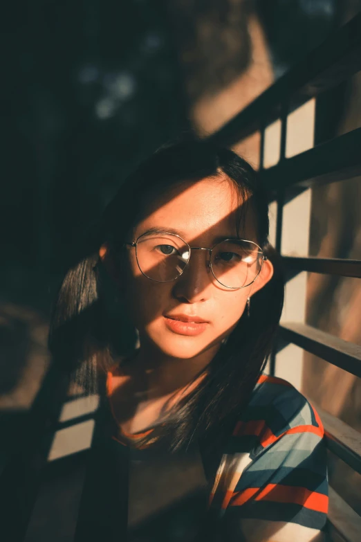 a woman wearing glasses sitting on the outside steps