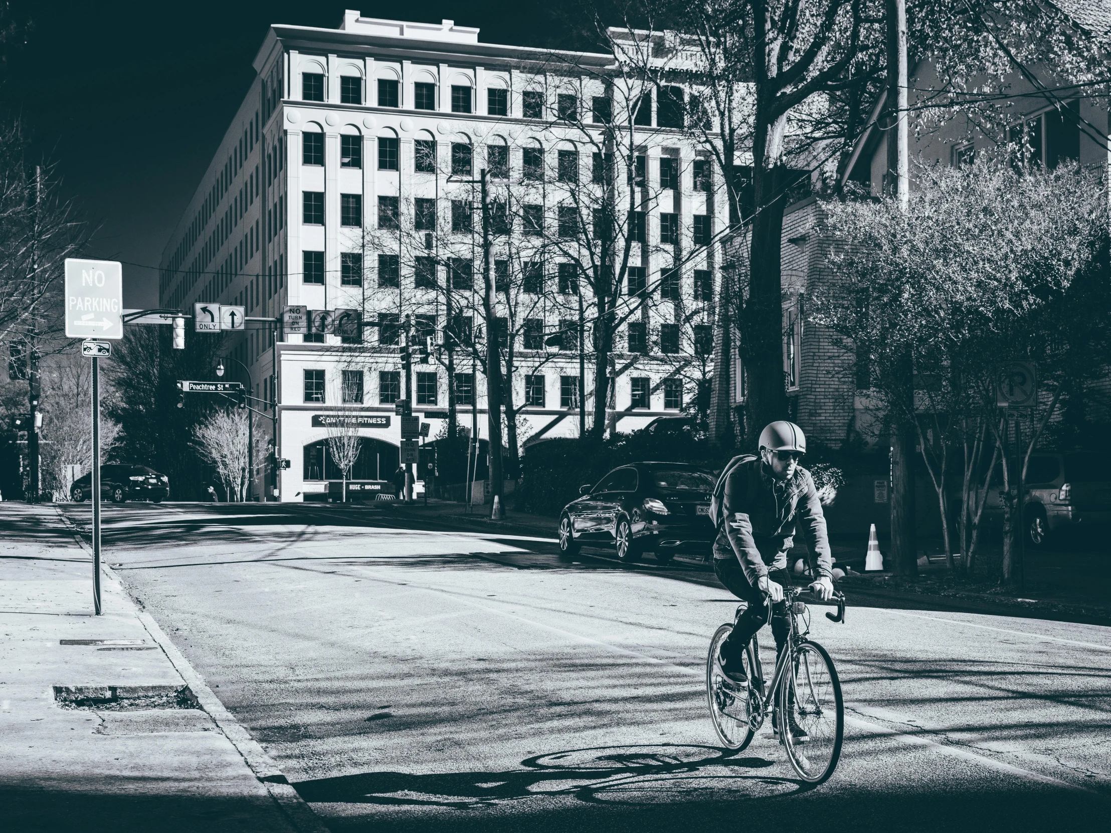 an old black and white po shows a woman riding her bicycle through the town