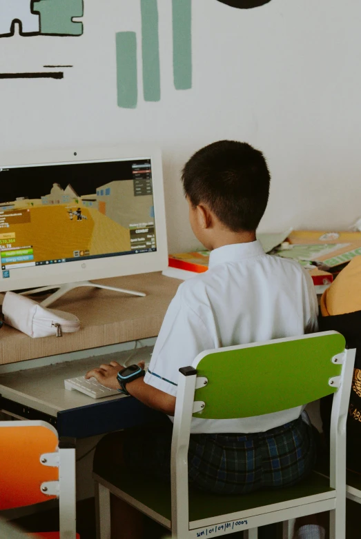 a  sitting in a chair at a desk playing video games