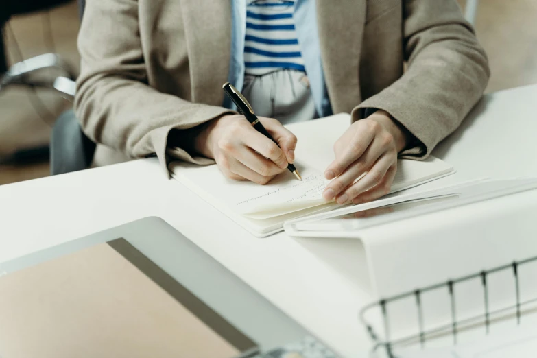 a person writing on notebook in office setting