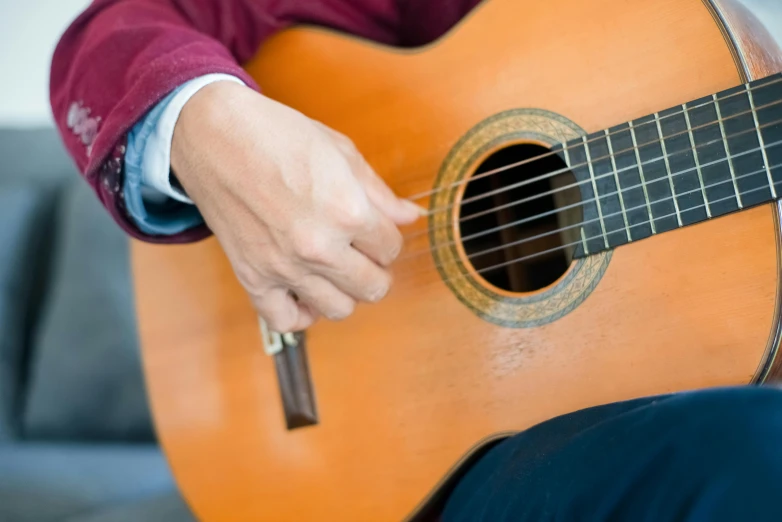 a close up of a person playing an acoustic guitar