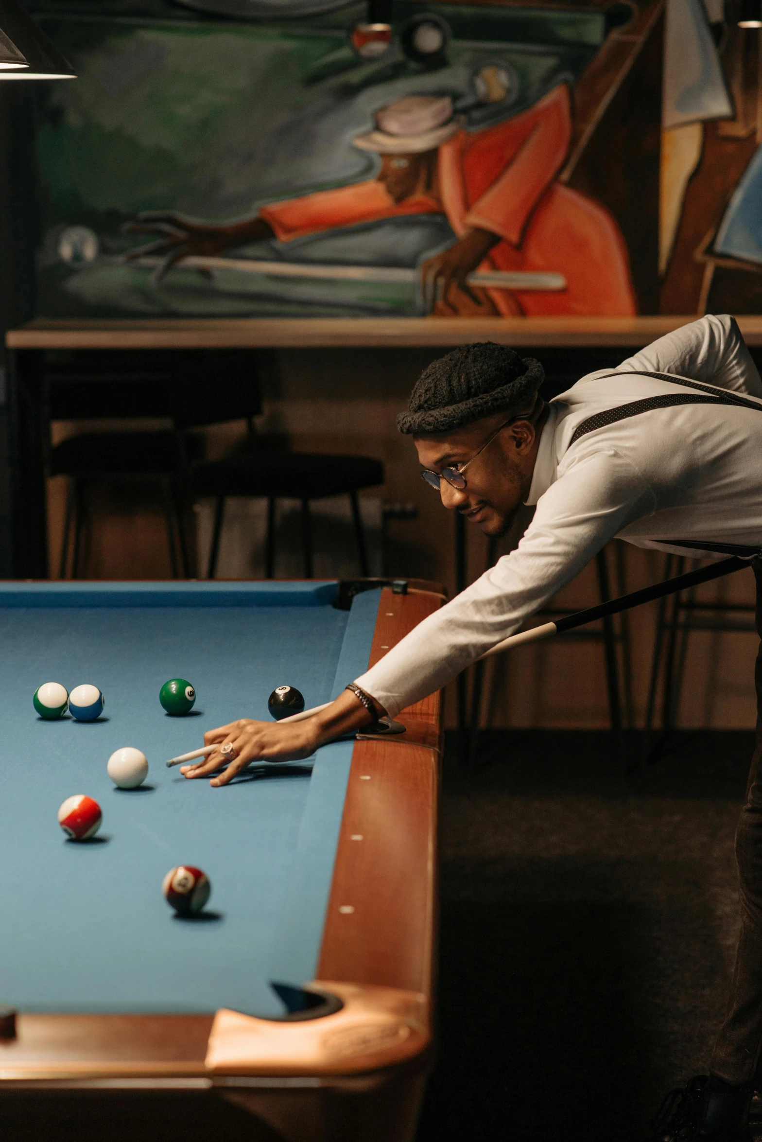 a man leaning over a pool table preparing to shoot a ball